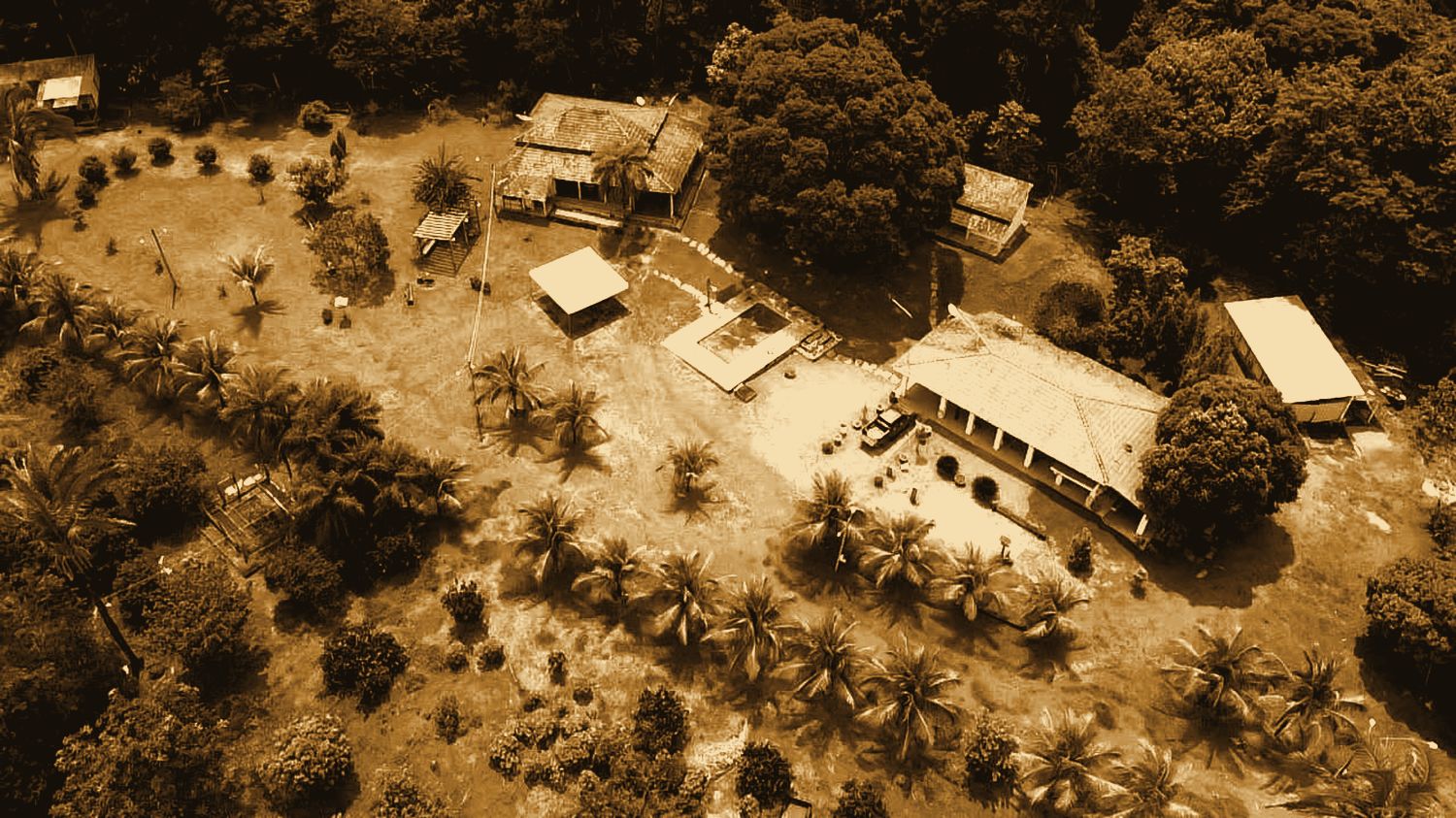 Vista aérea do conjunto do rancho, com as casas, a piscina e o coqueiral